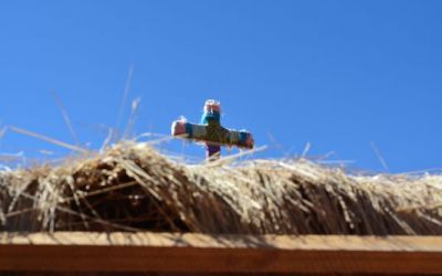 a-colourful-cross-on-top-of-the-straw-roof-of-machuca-houses