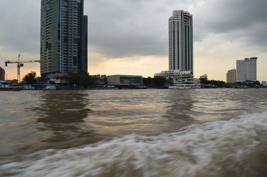 sunset above skyscrapers on Chao Phraya river in Bangkok