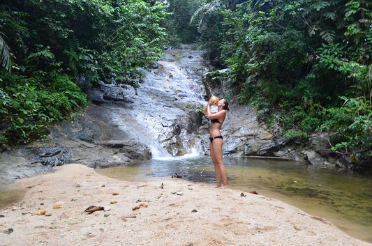 crazy sexy fun traveler drinking fresh coconut in a secret waterfall in Ipoh
