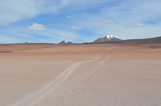 Desierto de Siloli surrounded by snow-capped mountains
