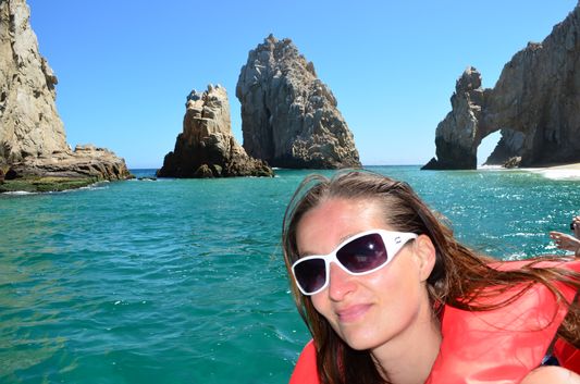 crazy sexy fun traveler with Los Arcos in Los Cabos behind